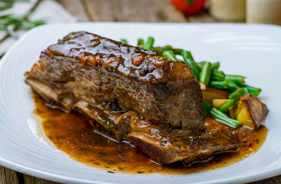 Beef Short Ribs braised until juicy and delicious with a side of vegetables. 